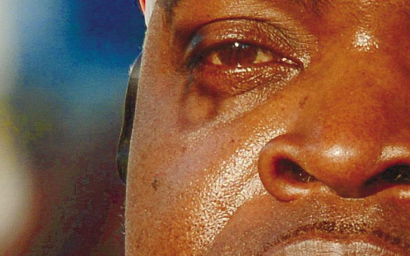 A tiny heartshaped shadow is cast below Frederick Scott Sr.’s eye, probably from a fastener on a nearby memorial balloon, as he listens to words of remembrance during a ceremony for his son, Frederick Jr., who was shot and killed at a Shell gas station in downtown Eatonton.