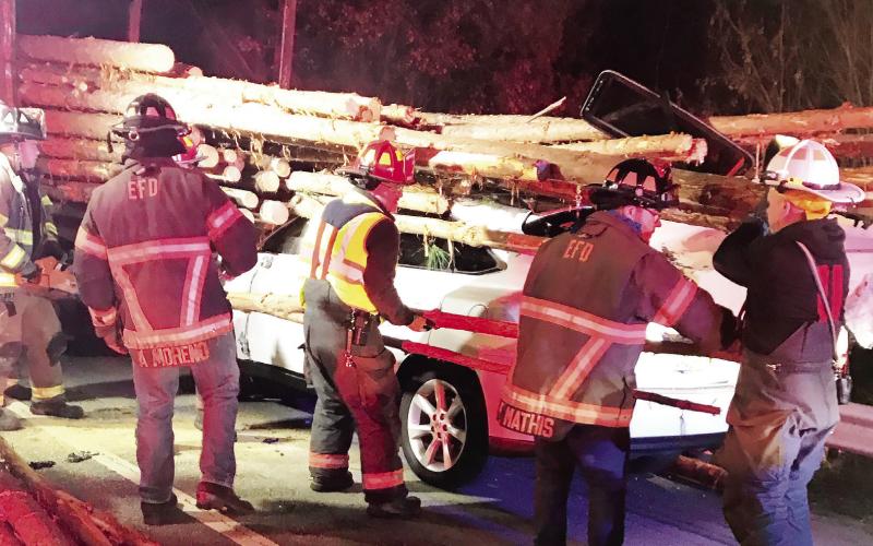Eatonton Fire Department first responders work to rescue a driver trapped in an SUV after crashing into a log truck Monday. CONTRIBUTED/EPD