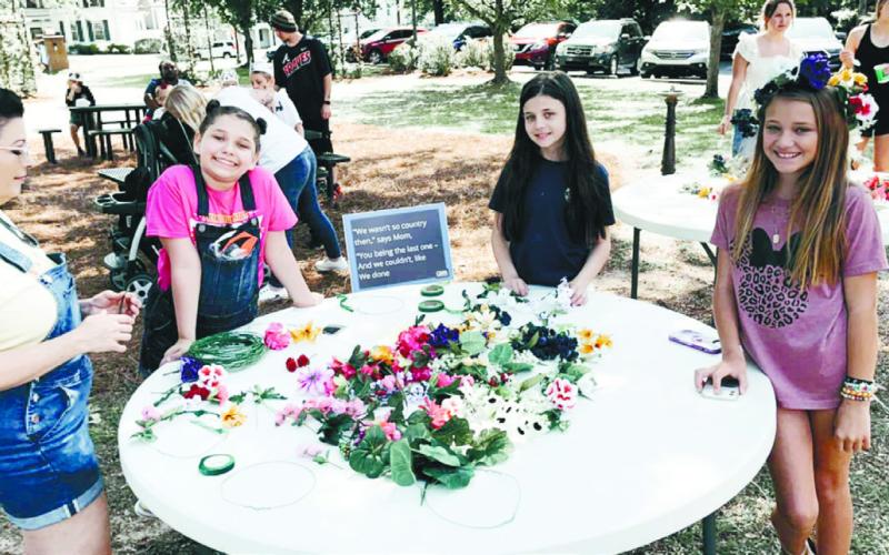 Attendees of last year’s spring event make flower crowns. CONTRIBUTED