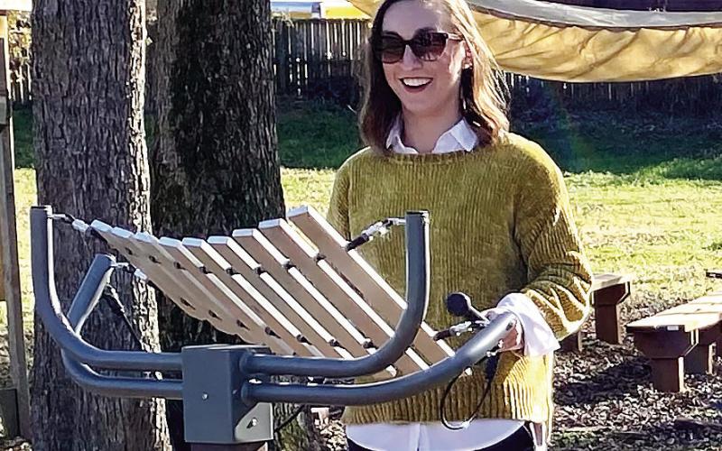 Maggie Milner, chair and CEO of Eatonton-Putnam Chamber of Commerce, enjoys playing a percussion instrument installed at Butterflies &amp;amp; Blooms in the Briar Patch after her raffle ticket number was called. EMME CLAUSE/Staff