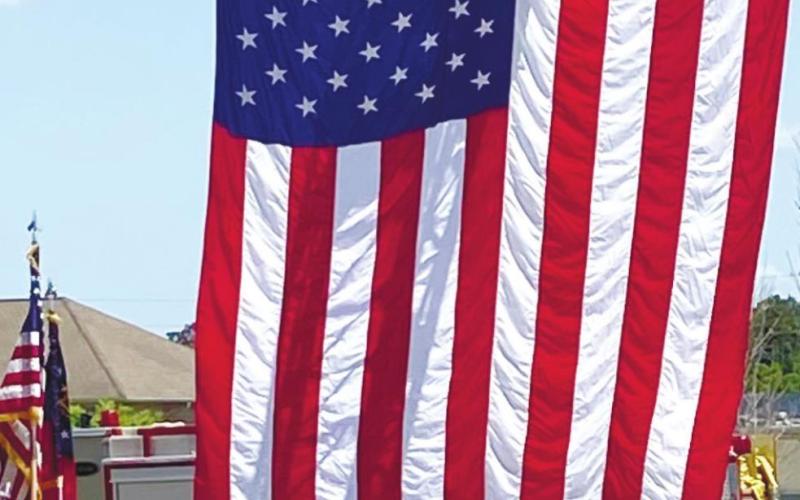 A huge American flag sways in the breeze against a blue sky, provided by Putnam County Fire Department for the veterans ceremony at Harbor at Harmony Crossing Assisted Living. CONTRIBUTED