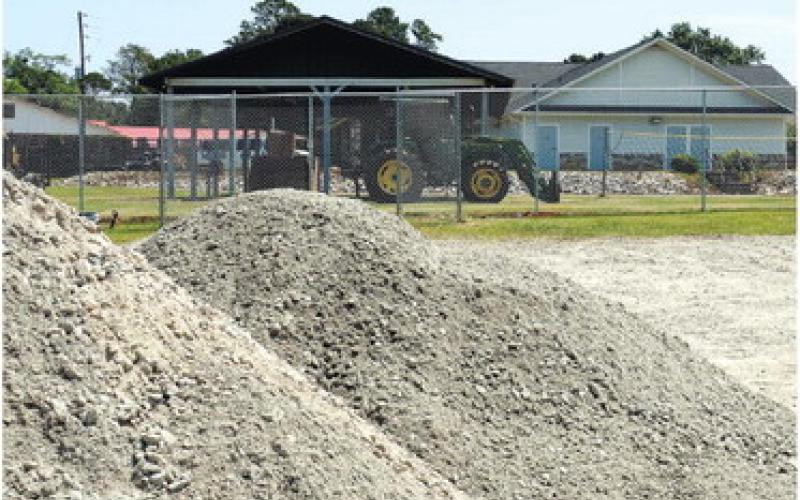 Large mounds of dirt await grading in the parking lot, while the Jimmy Davis Park building (right) is next in line for an update and repairs. IAN TOCHER/Staff