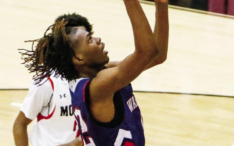 Putnam County’s Shamar McClendon soars over a Morgan County defender for an easy layup. LANCE McCURLEY/Staff