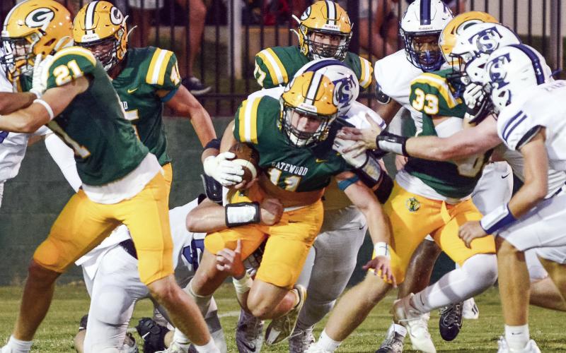 Gatewood junior Mason Sinclair (11, center) fights for every inch of turf Friday night in a disappointing 28-12 loss to the visiting Trinity Christian Crusaders. IAN TOCHER/Staff