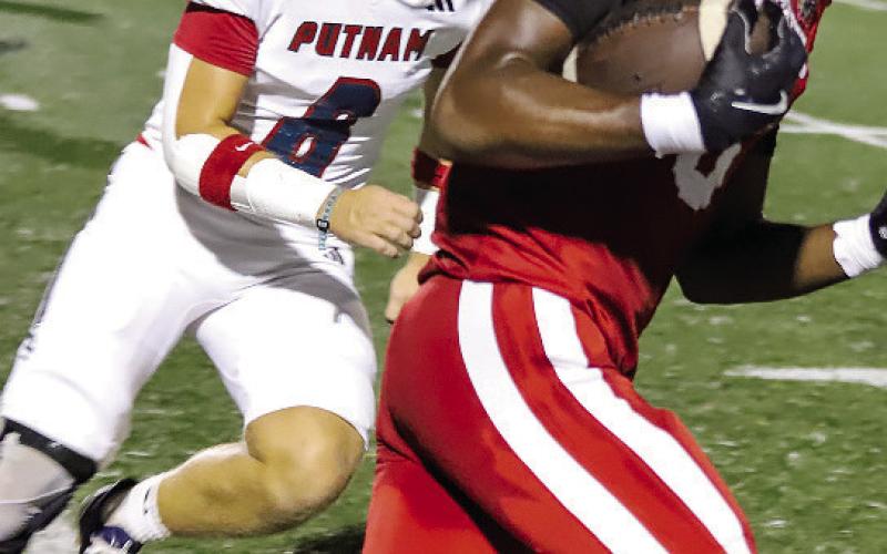 A Social Circle ball carrier runs past Putnam County senior linebacker Branan Griffin (8). Courtesy of Brendan Koerner