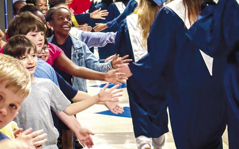 Seniors walk down the hall of Putnam County Elementary School and high five students as they pass by. CONTRIBUTED