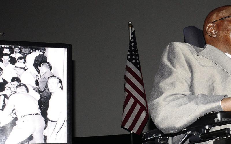 Freedom Rider Charles Person speaks alongside a copy of a historic photo that may have played a part in once saving his life. IAN TOCHER/Staff