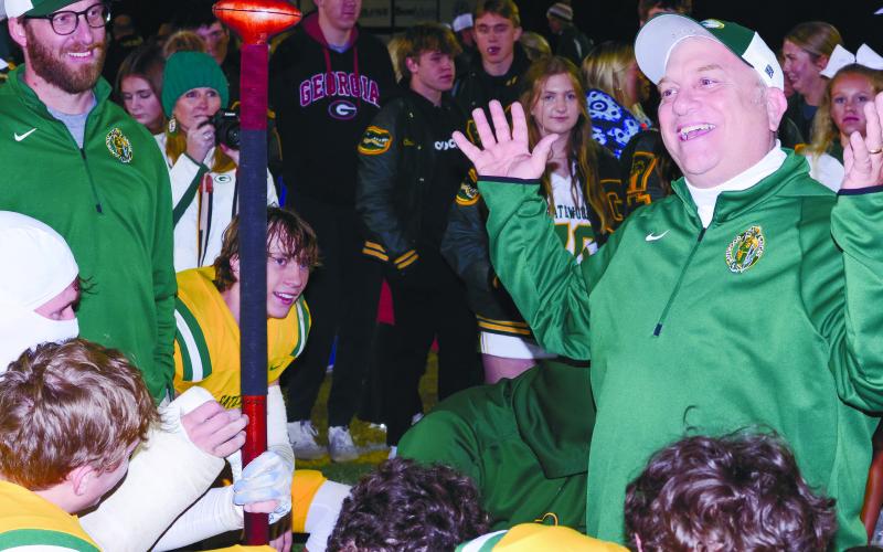Gatewood head coach Jeff Ratliff (right) was all smiles after his Gators won back the “Whoopin’ Stick,” held by star player Evan Bennett, who had on a cast covering most of his right forearm in a return to play after missing several games due to an injury suffered earlier this season. IAN TOCHER/Staff