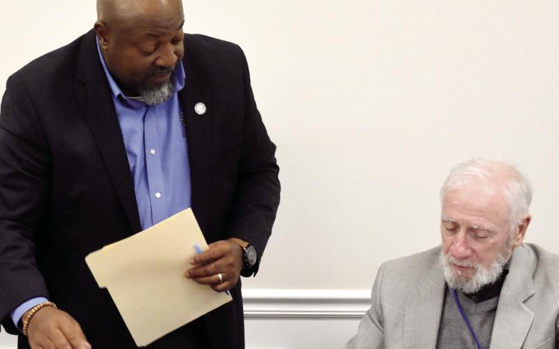 Derick Austin (left), who was named the next superintendent of PCCSS to succeed Erica Arena, leans over Board Chair Dr. Steve Weiner’s shoulder as board members sign the approved contract. BAILEY McCULLY/Staff
