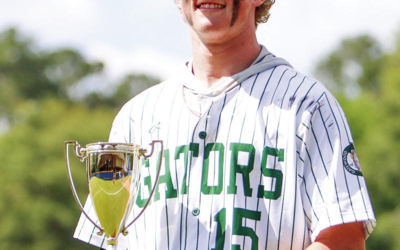 Lawson Wooten holds the 2024 GIAA-2A state championship trophy after closing with two scoreless innings for the Gators in Macon. LANCE McCURLEY/Staff