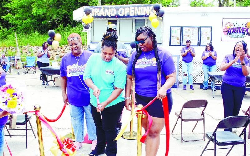 Surrounded by friends, family and well-wishers, Anfrankina “Kina” Little (center) cuts the ribbon to officially open Kina’s Krazy Kreations, her new roadside restaurant alongside Hwy. 44 on Eatonton’s south side. IAN TOCHER/Staff