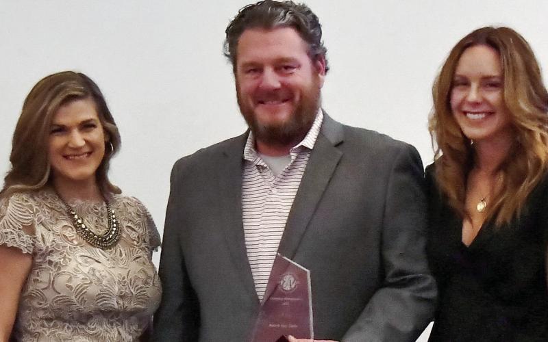 Sean and Sara Tintle, of Red Bird Georgia Property Management, received their award from Katie Strickland (left) of Shafer Partners. IAN TOCHER/Staff