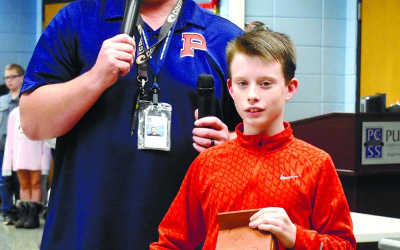Coach Pope and Mason show how to open the bluebird bird houses. BAILEY McCULLY/Staff