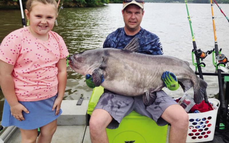 Guy Covington and his young daughter show off the record-setting 79.5-pound catfish he caught last month near Oconee Springs Park on Lake Sinclair. Georgia Outdoor News