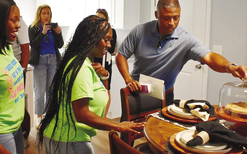 Warrick Dunn reaches for an apple pie on the table, explaining to Carla that for him, the apple pie turns the house into a home.