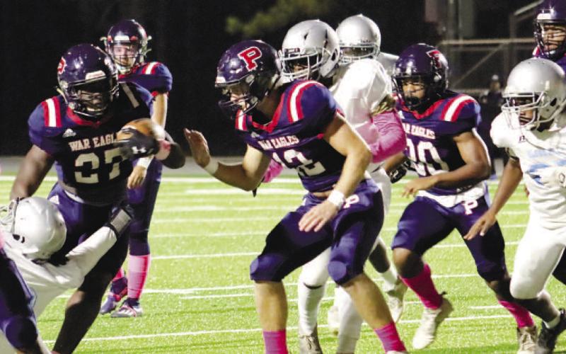 Tamarion Peters (27) breaks through defenders for a chunk gain. Photos by ARELLA CASH/Staff