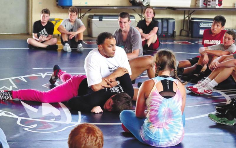 Bryce Carr with help from Tristan Lower demonstrates hold for wrestlers. ARELLA CASH/Staff