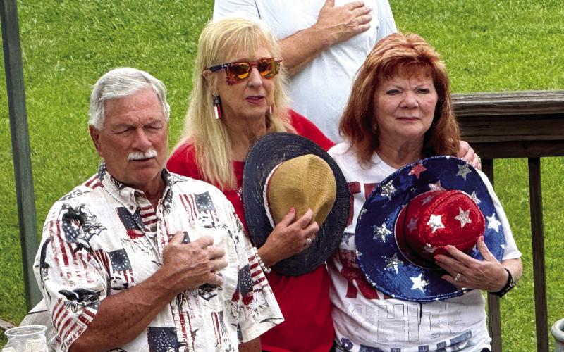 Local residents arrived by boat and car to Duke’s Lounge and Dawg House in Milledgeville for Memorial Day ceremonies, including the Pledge of Allegiance, delivered by Georgia Bulldogs broadcaster Jeff Dantzler. IAN TOCHER/Staff