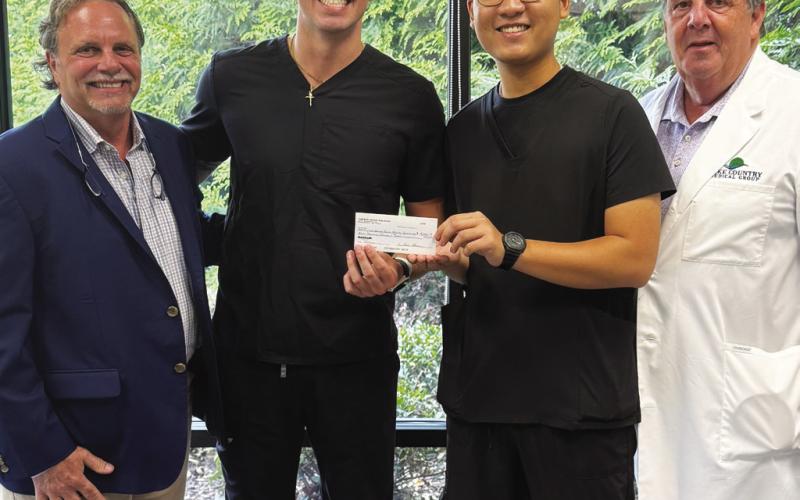 LCCHF Event Coordinator Tom Hanscom (above, l-r) presented an $8,000 check to Michael “Baylor” Edge and Martin Ton, who accepted the check on behalf of the Lake Country Rural Health Initiative, with LCCHF Medical Director Dr. Nicolas Chronos. CONTRIBUTED