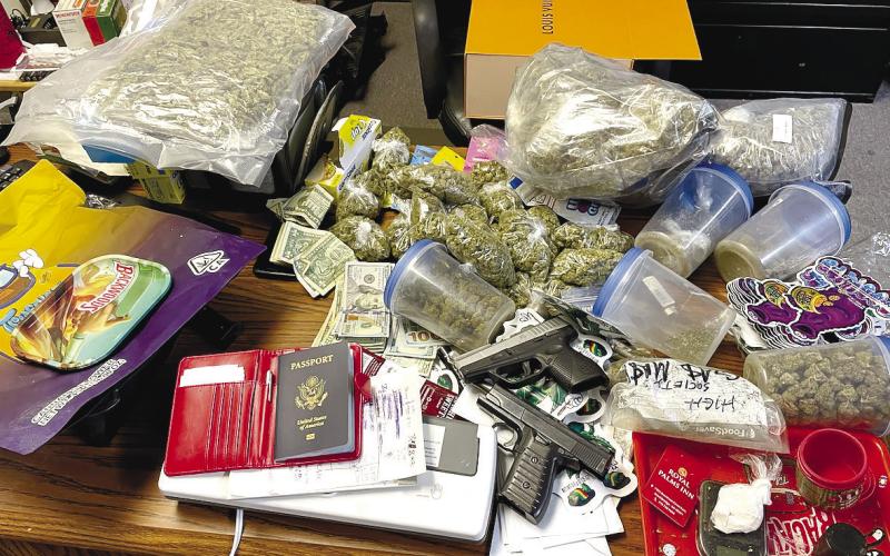 Five pounds marijuana packaged for selling, powder cocaine, handguns, cash, vape pens, a passport, and other items pictured were seized by local authorities last week. CONTRIBUTED