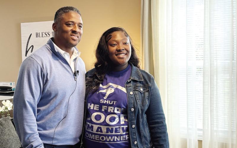 NFL star Warrick Dunn with I’Keirra in the living room of her brand-new home. EMME CLAUSE/Staff