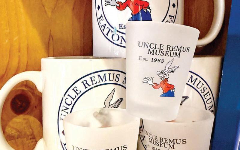Small wooden yo-yos (bottom left) share space at the Uncle Remus Museum gift shop with more traditional offerings like museum-branded t-shirts, mugs, and drinking glasses. IAN TOCHER/Staff