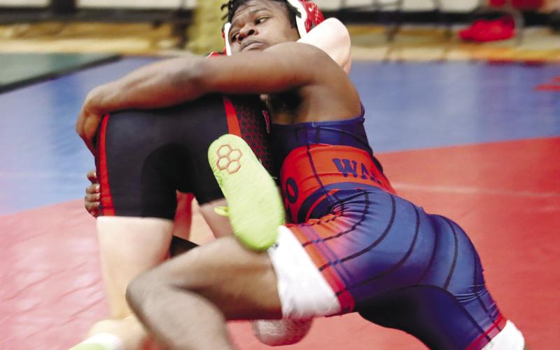 Brayon Farley takes hold of one of his opponents, trying to pin him to the ground.
