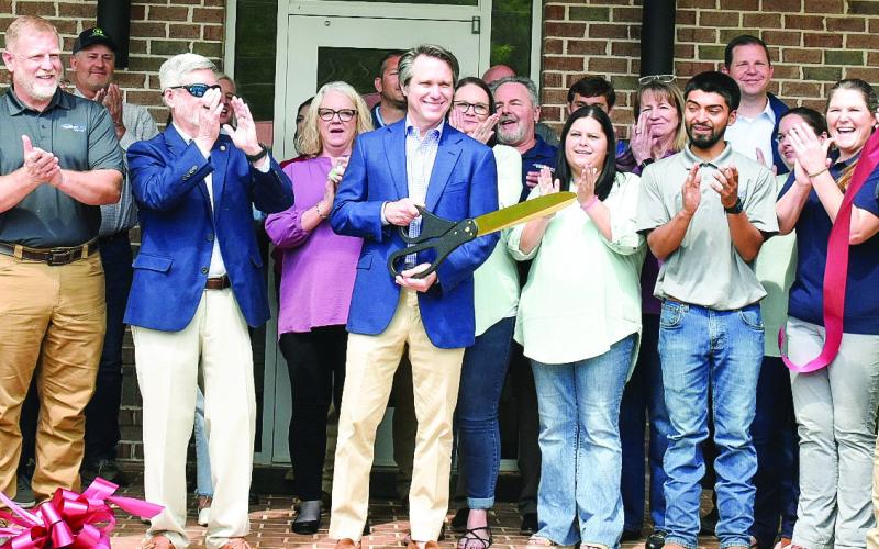Piedmont Water owner Adam Shaifer (center) cuts the ribbon for the company’s Customer Care and Learning Center April 15 as employees, the Eatonton-Putnam Chamber of Commerce, Greene County Chamber of Commerce, and community members celebrate. HANNAH BARRON Staff