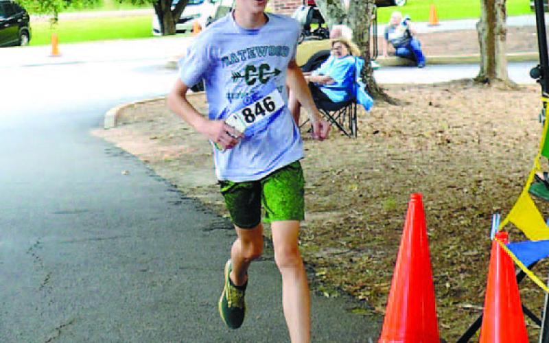 Winning time: Eighth-grade Gatewood student Cale Ferguson, 14, crosses the finish line in 22 minutes, 5 seconds to win the overall and men’s title for the 14th annual 5K for Kaye Swamp Stomp. IAN TOCHER/Staff
