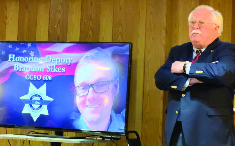Putnam County Sheriff Howard Sills stands beside an image of Columbia County Deputy Sheriff Brandon Sikes, who was shot and killed April 26 while making a traffic stop on I-20, near Augusta. IAN TOCHER/Staff