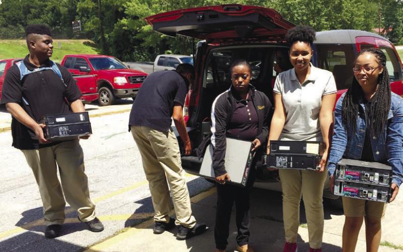 CONTRIBUTED Students help move donated computers destined for use in Habitat for Humanity homes