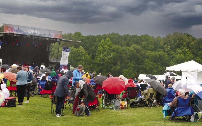 Mother Nature brought strong winds and heavy rain, which changed the program, but the show still went on as attendees huddled under umbrellas and bundled up in rain coats to brace for the elements.