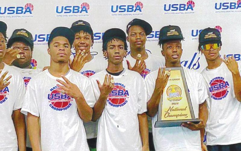 The EMPACT basketball team and coaches display their trophy and championship rings after the national title game. CONTRIBUTED