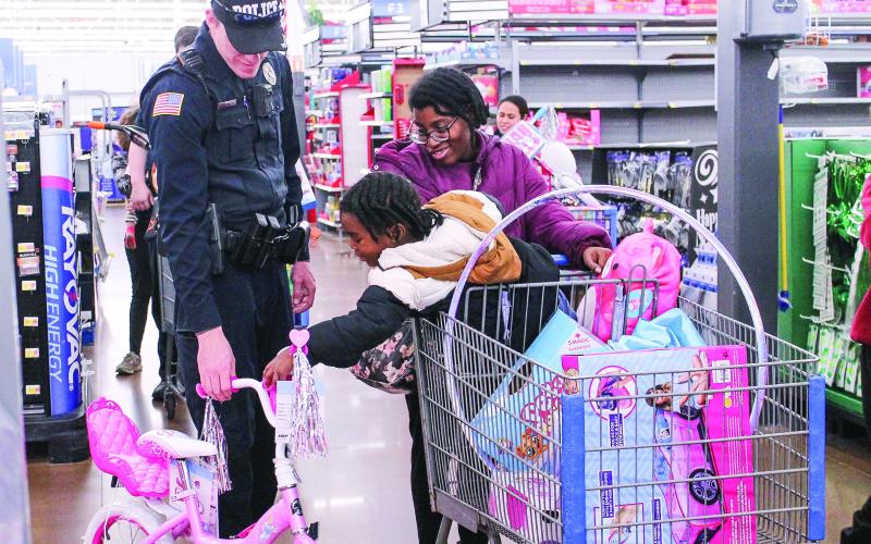 Athena Hall, 5, demonstrates the music player on her new bicycle for Officer Chris Detweiler. JEREMY MCCLURE/Contributed
