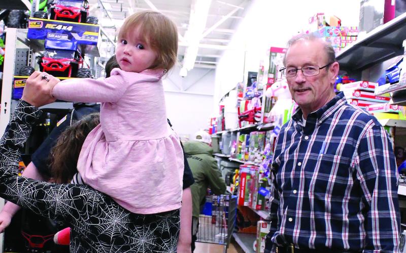 One of the younger shoppers looks back as Eatonton Police Chief Howell Cardwell ensures everyone is finding what they want. LYNN HOBBS/Staff