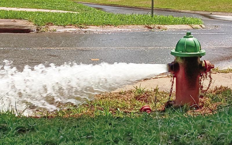 An uncapped fire hydrant alongside Eatonton’s Willie Bailey Street relieves water pressure to allow repairs further down the line. BRANDON PARK/Staff