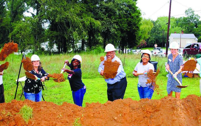 IAN TOCHER/Staff Flanked by soon-to-be new homeowners and Habitat for Humanity representatives, including Putnam County Habitat Executive Director Murali Thirumal (far right) and Eatonton Mayor John Reid (center).