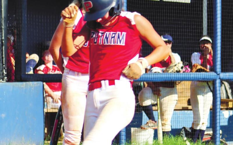 Jenna McDerment ducks as she crosses home plate for another Lady Eagles score.