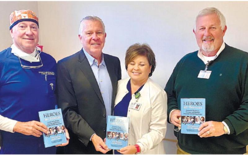Putnam General Hospital urologist Bob Cowles, author Bob Delaney, Pam Douglas and PGH CEO Alan Horton display copies of Delaney’s new book, Heroes are Human. CONTRIBUTED