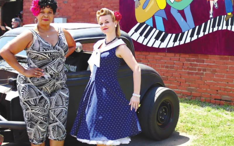 Members of Lifers Car Club pose with hot rod. Behind them, one of the many signs along the studio can be seen. ARELLA CASH/Staff