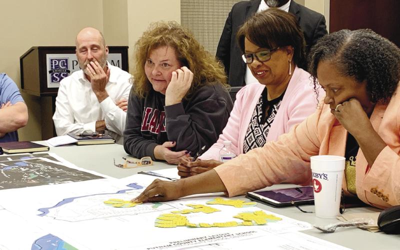 Board members test designs on the in-scale map while discussing budgetary concerns and the site. BAILEY BALLARD/Staff