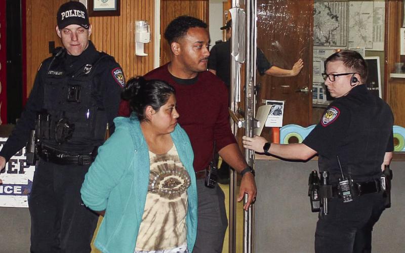 Reyna Lopez, front center, is escorted by Eatonton Police Department officers, from left, Chris Detweiler, Investigator Hargrove Jones and Jeremy McLure, who are taking Lopez to jail at Putnam County Sheriff’s Office. CONTRIBUTED/EPD