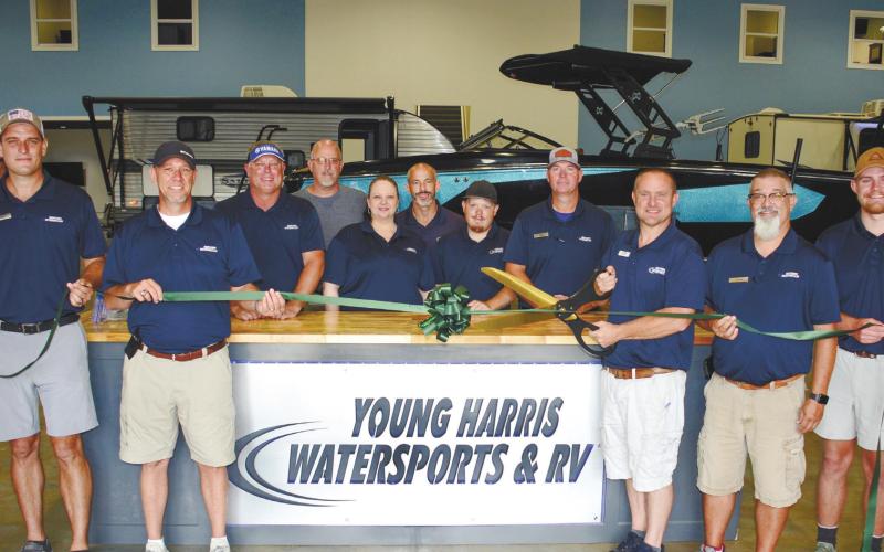 Surrounded by employees new and old, Young Harris Watersports and RVs owner Lance Markham prepares to cut the ribbon. IAN TOCHER/Staff