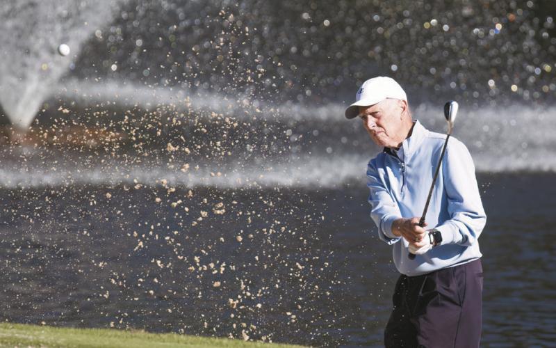 Doug Denholm hits a shot out of the bunker onto the green. LEIGH LOFGREN/Staff