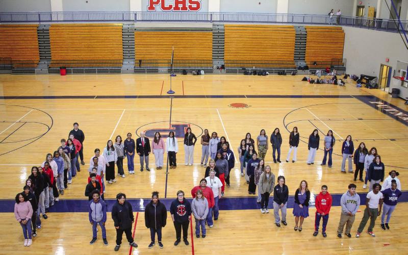 Members of the Putnam County High School Key Club, including President Carolyn Thomas (in pink, back of center “0”) pay tribute to the Eatonton Kiwanis’ 100th year of service to local communities. IAN TOCHER/Staff