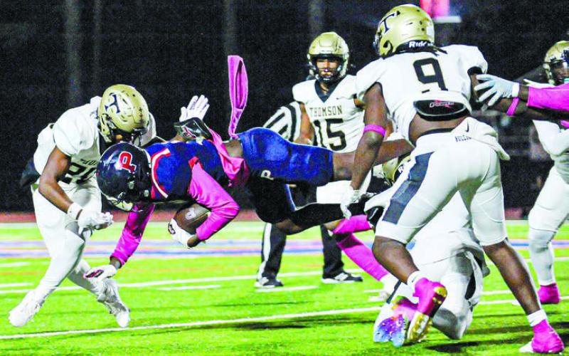 A high-flying Kaleb Crawford makes every effort to gain some yardage against Thomson earlier this year. CHARLES JORDAN/File photo