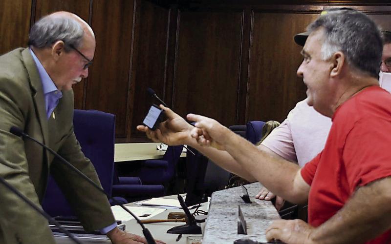 Local landowner Mark Thompson (right) addresses Putnam County Planning &amp;amp; Zoning Commissioner Charles Gray at the end of a tumultuous meeting March 5, as another citizen shows Gray a document on his phone. IAN TOCHER/Staff
