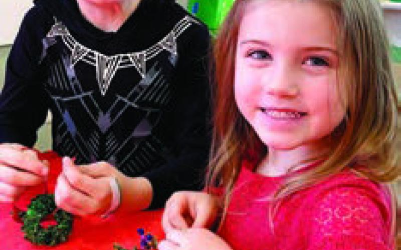 Hattie and Davis Swymer, ages 4 and 7, work hard on their fun Christmas wreath crafts. EMME CLAUSE/Staff
