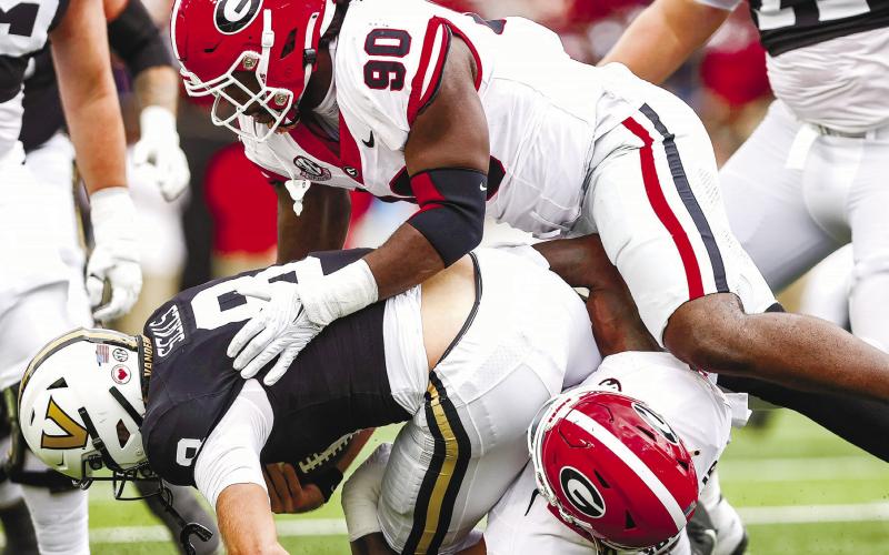 Georgia defensive lineman Tramel Walthour (90) and inside linebacker Smael Mondon Jr. (2) tackle Vanderbilt quarterback Ken Seals (8) during Saturday’s TONY WALSH/UGA Athletics game in Nashville.