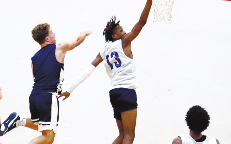 Cameron Stephens (13) goes up for a layup as Peyton Ellison (0) waits in the paint for a potential rebounding opportunity. ARELLA CASH/Staff